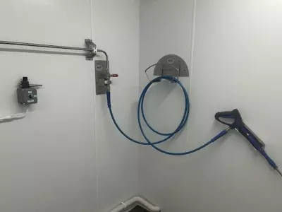 Close Up Stainless steel washroom with installed pipework, hose point and trigger gun connected to the wall-mounted pressure washer system in Nottingham Hose Reel And Valve